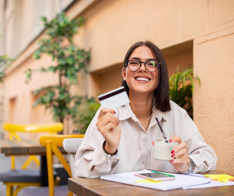 woman holding a drink and a bank card